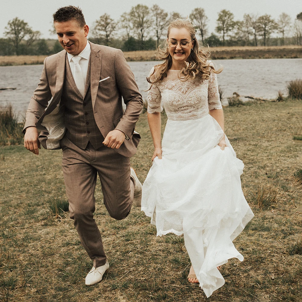 Suknia ślubna w stylu boho z warstwową koronką, dekoltem w łódkę, szyta na miarę, linia A, rękawki do połowy, rustykalna, ogrodowa, bohemiczna, romantyczna.