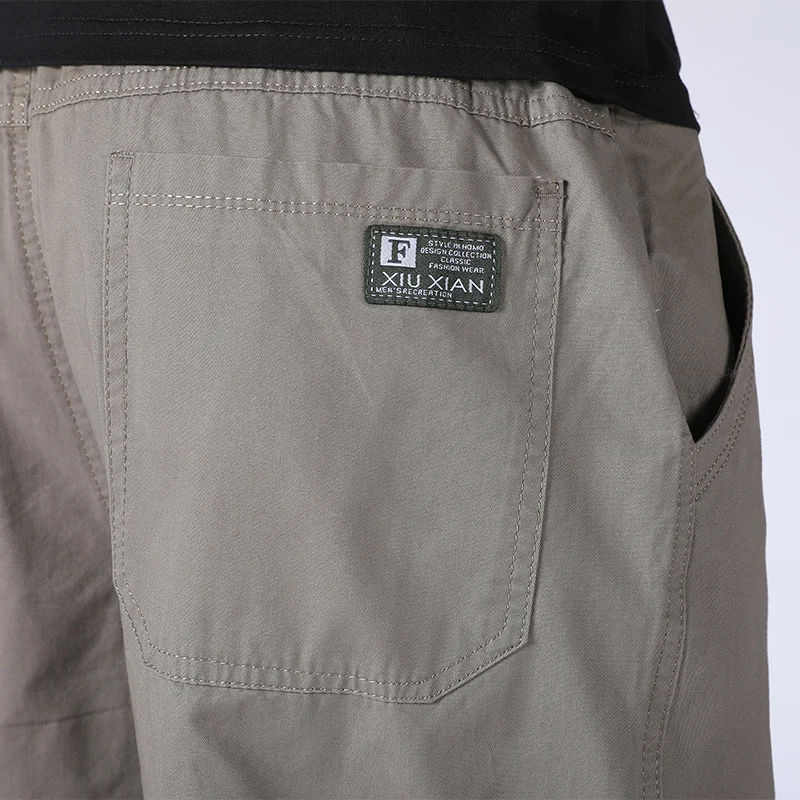 กางเกงขายาวผู้ชายผ้าคอตตอนเนื้อบางระบายกางเกงผู้ชายขาสามส่วนหลวมกางเกงขายาวแนวสตรีทแวร์สีล้วนใหม่ฤดูร้อน