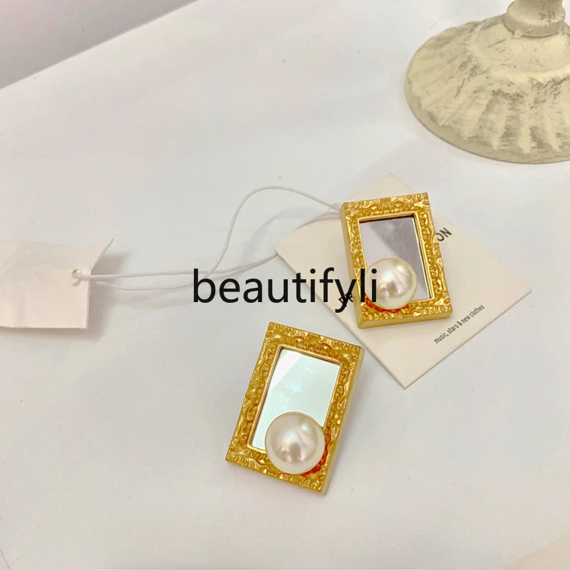 

The pearl earrings framed in the picture are simple and retro.