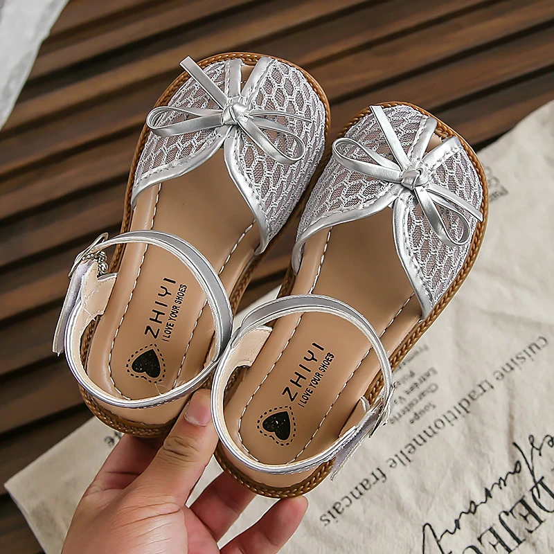 

2025 детские сандалии для девочек, новые летние модные нескользящие универсальные туфли принцессы в корейском стиле с мягкой подошвой и милым бантом