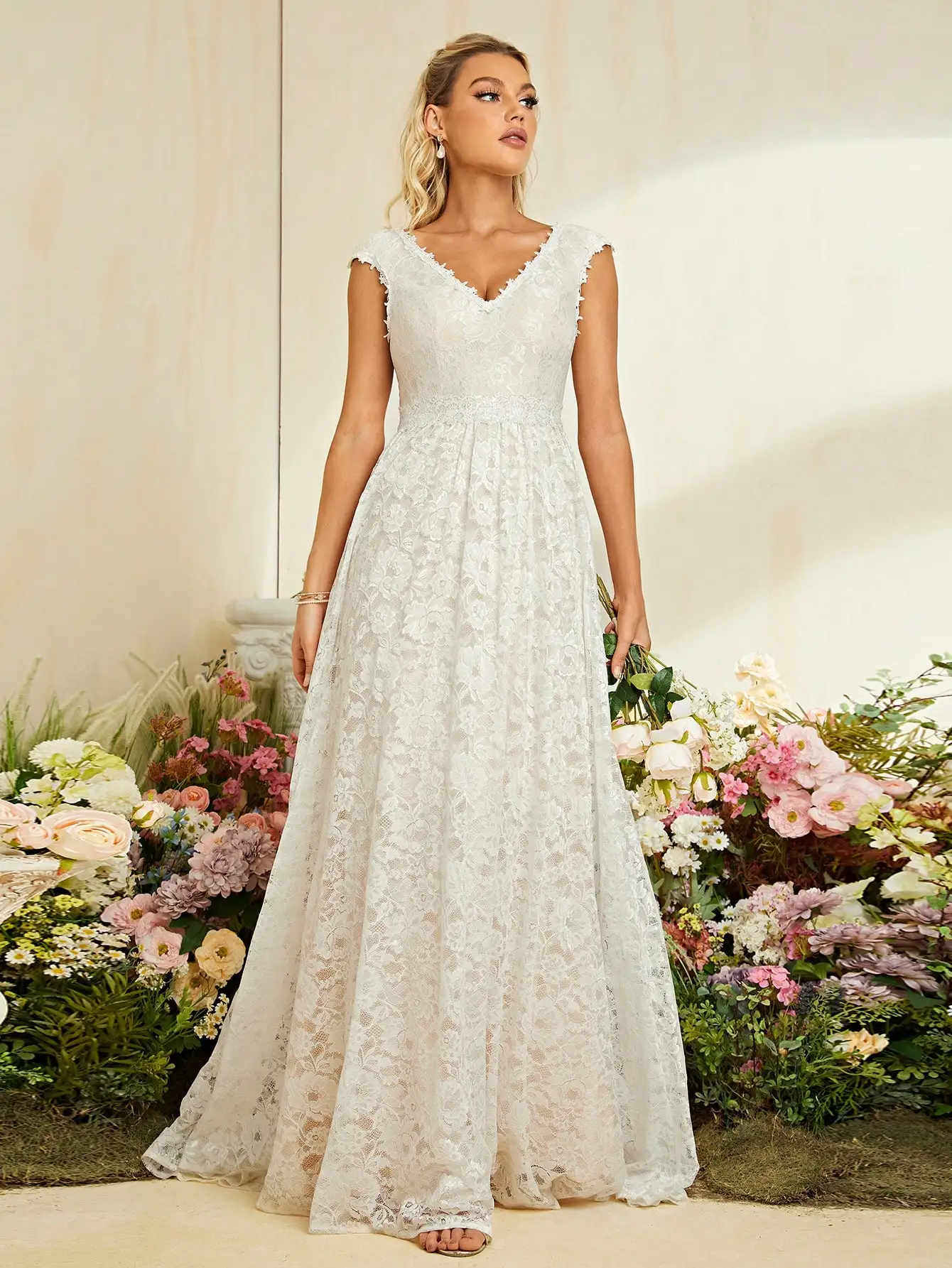 Suknia ślubna z dekoltem w kształcie litery V, zdobiona cekinami i koronką.