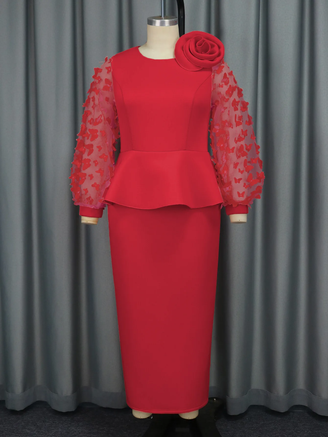 Elegancka sukienka wieczorowa plus size z falbanami w talii, kwiatami na ramionach i długimi, zwiewnymi rękawami z motywem motyla.