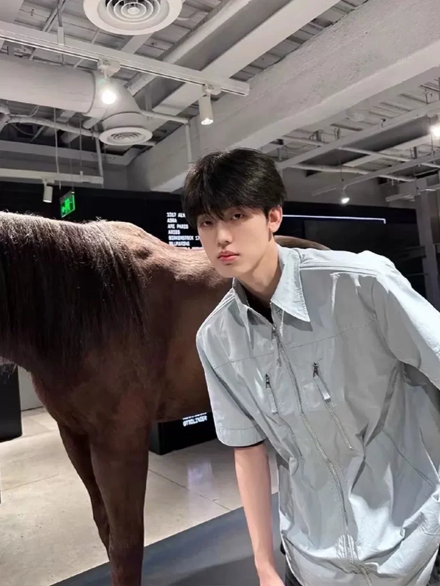 قميص رجالي كاجوال صيفي فضفاض بياقة مسطحة وأكمام قصيرة بخمسة أرباع طول الأكمام بلون أزرق فاتح وسحاب على الكتف