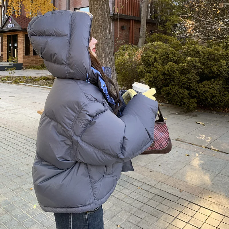 Kurtka puchowa damska z kapturem, blokowana kolorystycznie, zimowa 2025, nowa koreańska wersja, luźny krój, gruba i ciepła, uniwersalna kurtka typu chleb.