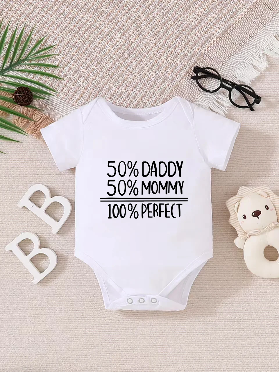 Playful letter-printed baby short-sleeve triangle bodysuit. Button closure for easy dressing