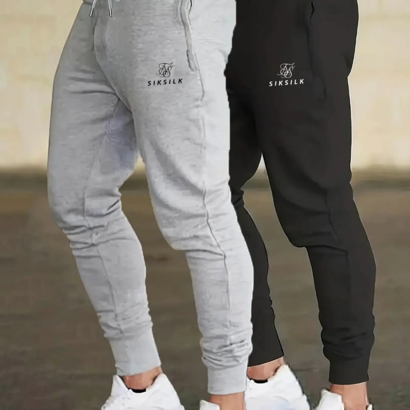 

Два мужских повседневных спортивных брюка с принтом в виде букв, с двойной застежкой на шнурках и без застежек на манжетах.