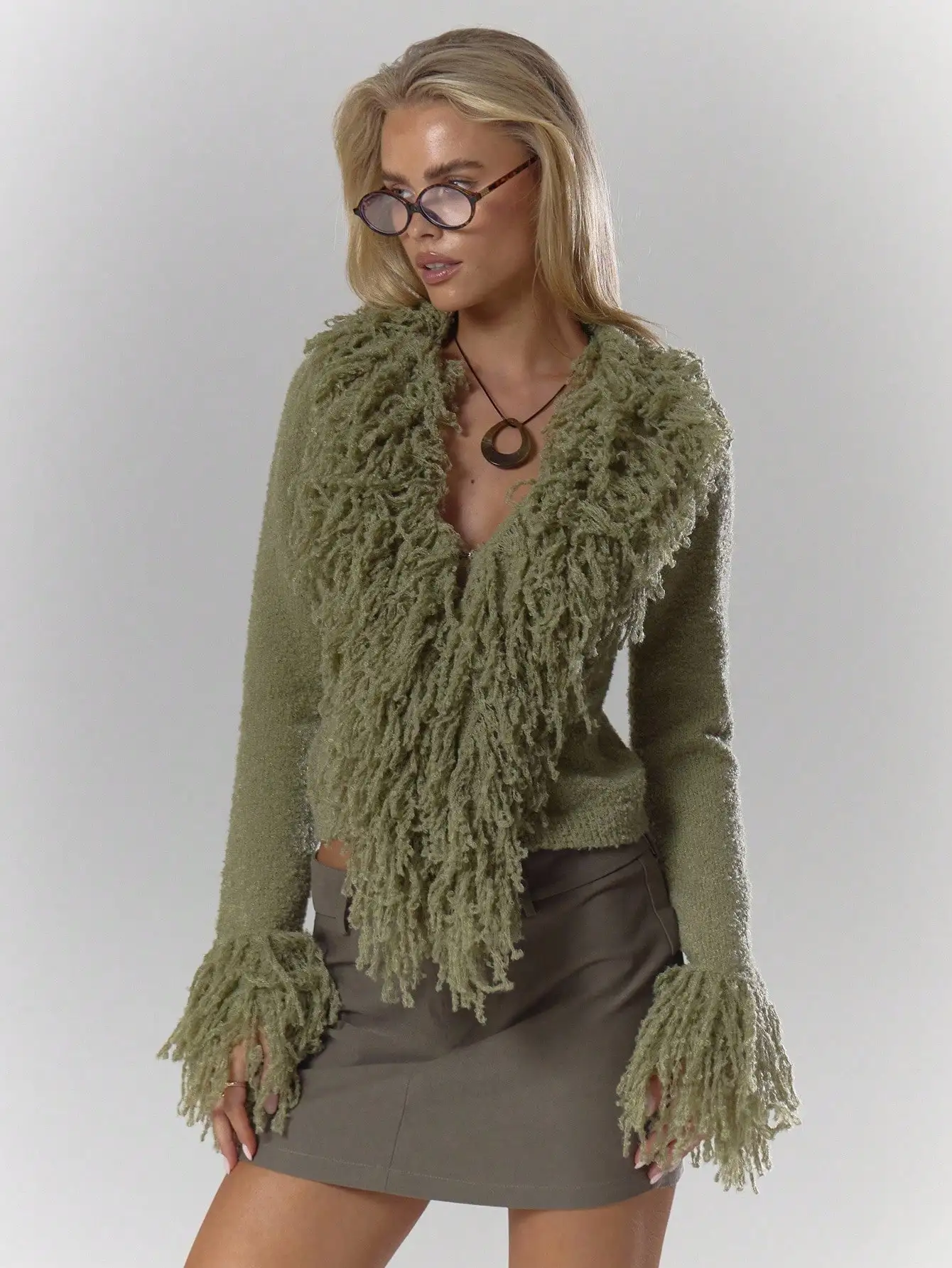 Kardigan w kolorze oliwkowej zieleni z puszystym wykończeniem i rękawami z frędzlami, idealny na jesień i zimę, zapewniający elegancję na co dzień.