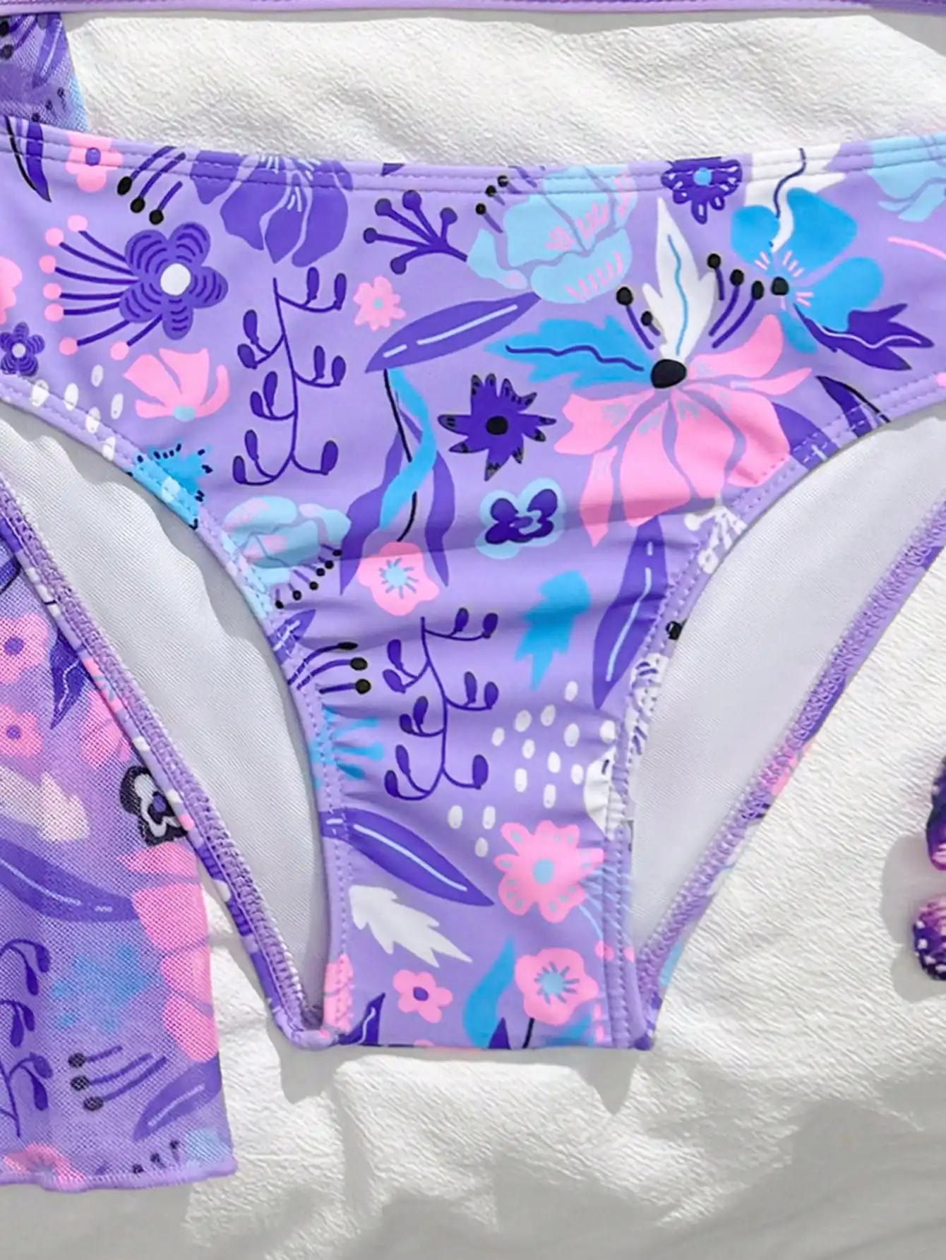 

Фиолетовый комплект из трех предметов: купальник с цветочным принтом и накидка