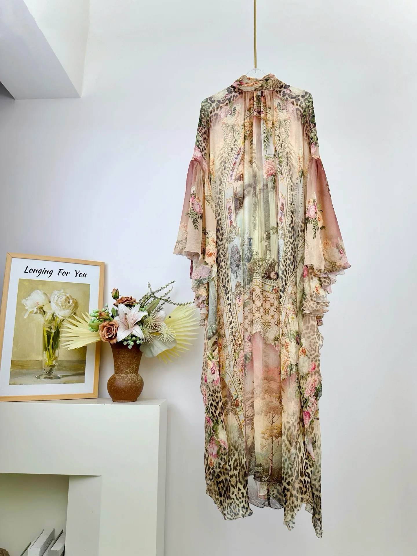 Damska sukienka z wysokim dekoltem, rękawami typu nietoperz, luźna, długa, jedwabna, w różowy wzór w panterkę.