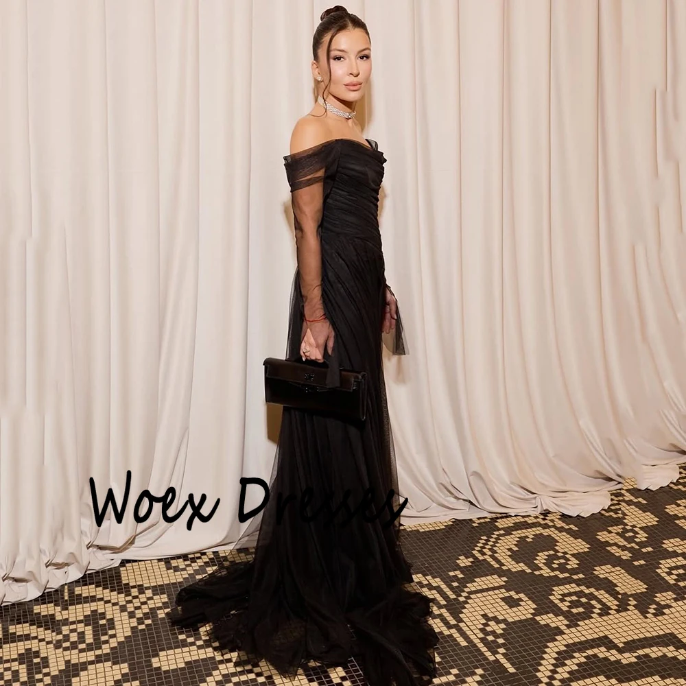 Sukienka wieczorowa z czarnego tiulu z dekoltem w łódkę, z iluzorycznymi, długimi rękawami, trenem zamiatającym, odkrytymi plecami, do ziemi, idealna na studniówkę.