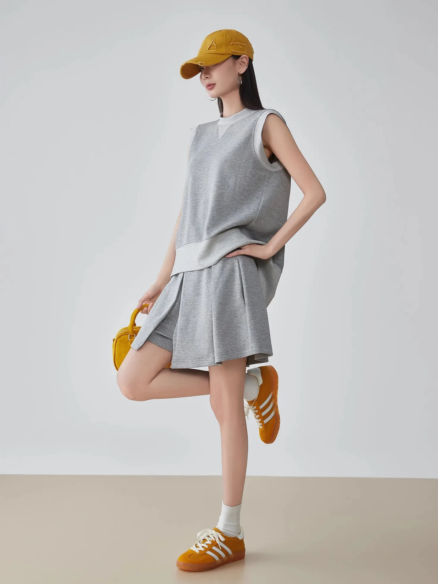 

Повседневный спортивный комплект: свободная футболка с круглым вырезом, топ-жилет и шорты. Модный женский комплект из двух предметов.