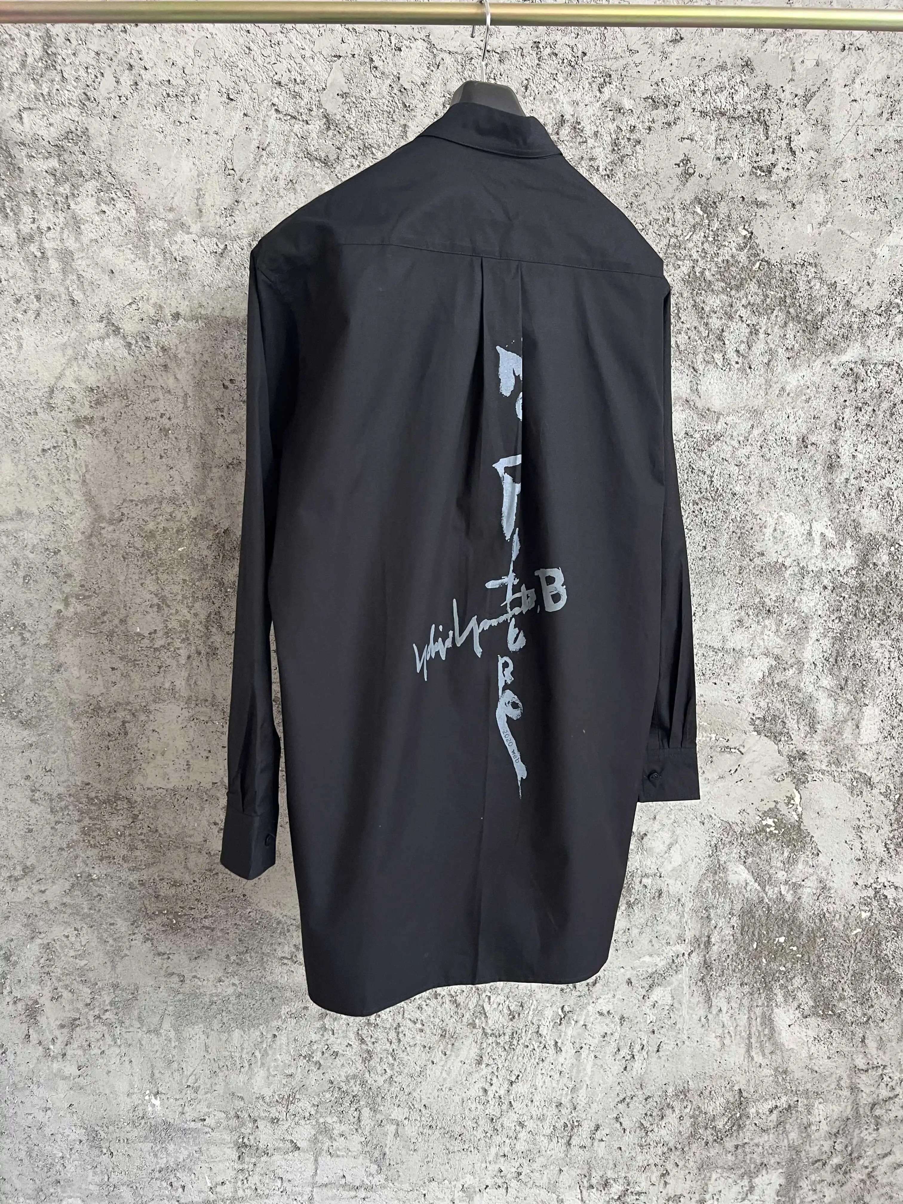 A simple long-sleeved single-breasted shirt with a double-layered collar, solid color and asymmetrical design