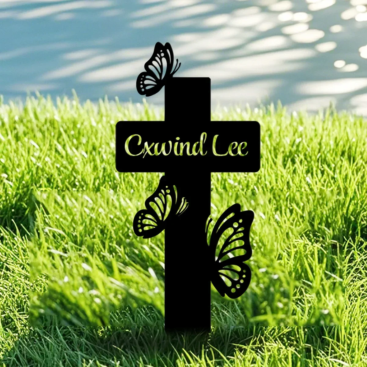 Onore amato con un palo commemorativo personalizzato con croce a farfalla, personalizzato e bello, che tocca l'homenuto del tomba in metallo nel giardino