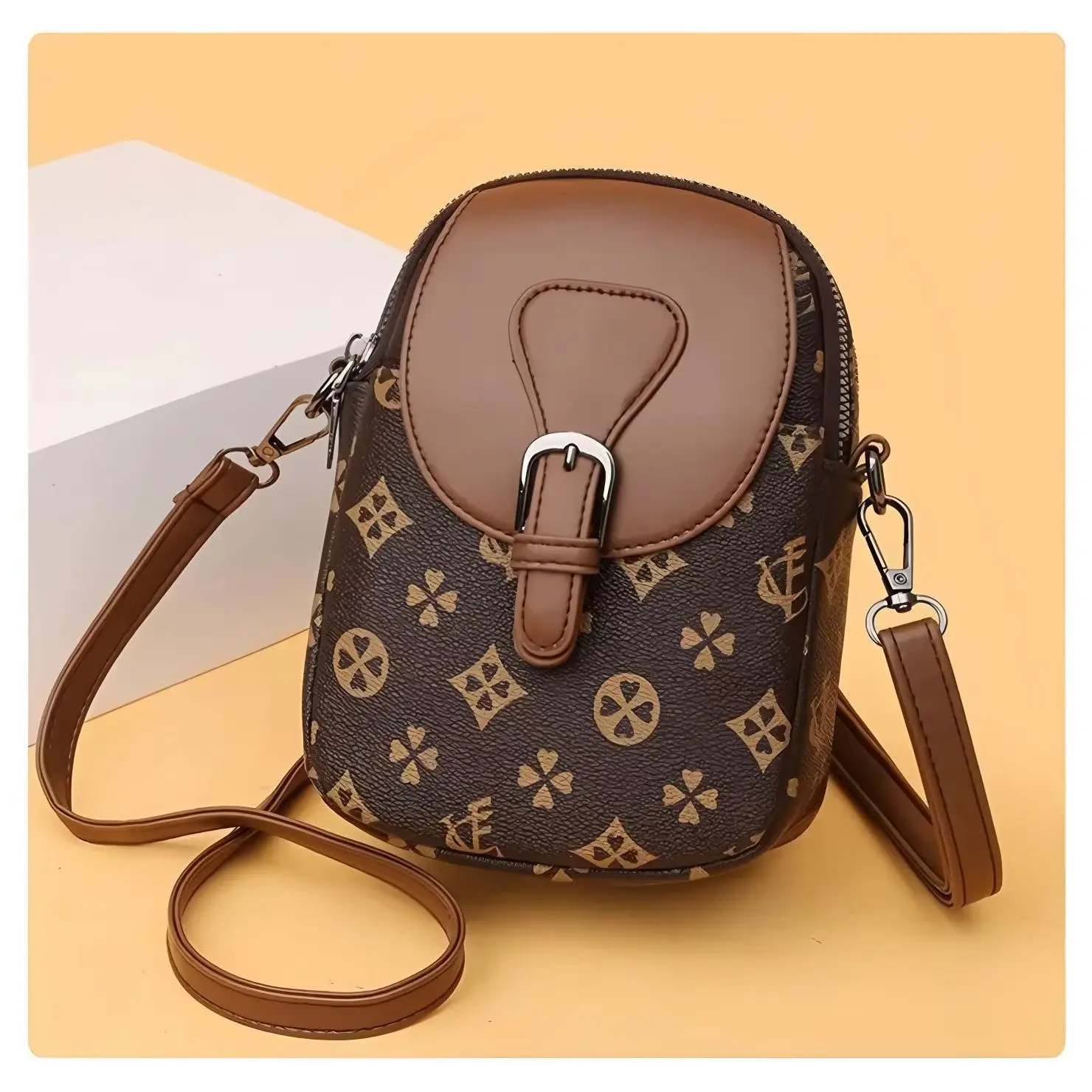 Retro floral letter mini vertical crossbody bag with a brown leather flap and buckle closure, adjustable thin shoulder strap.