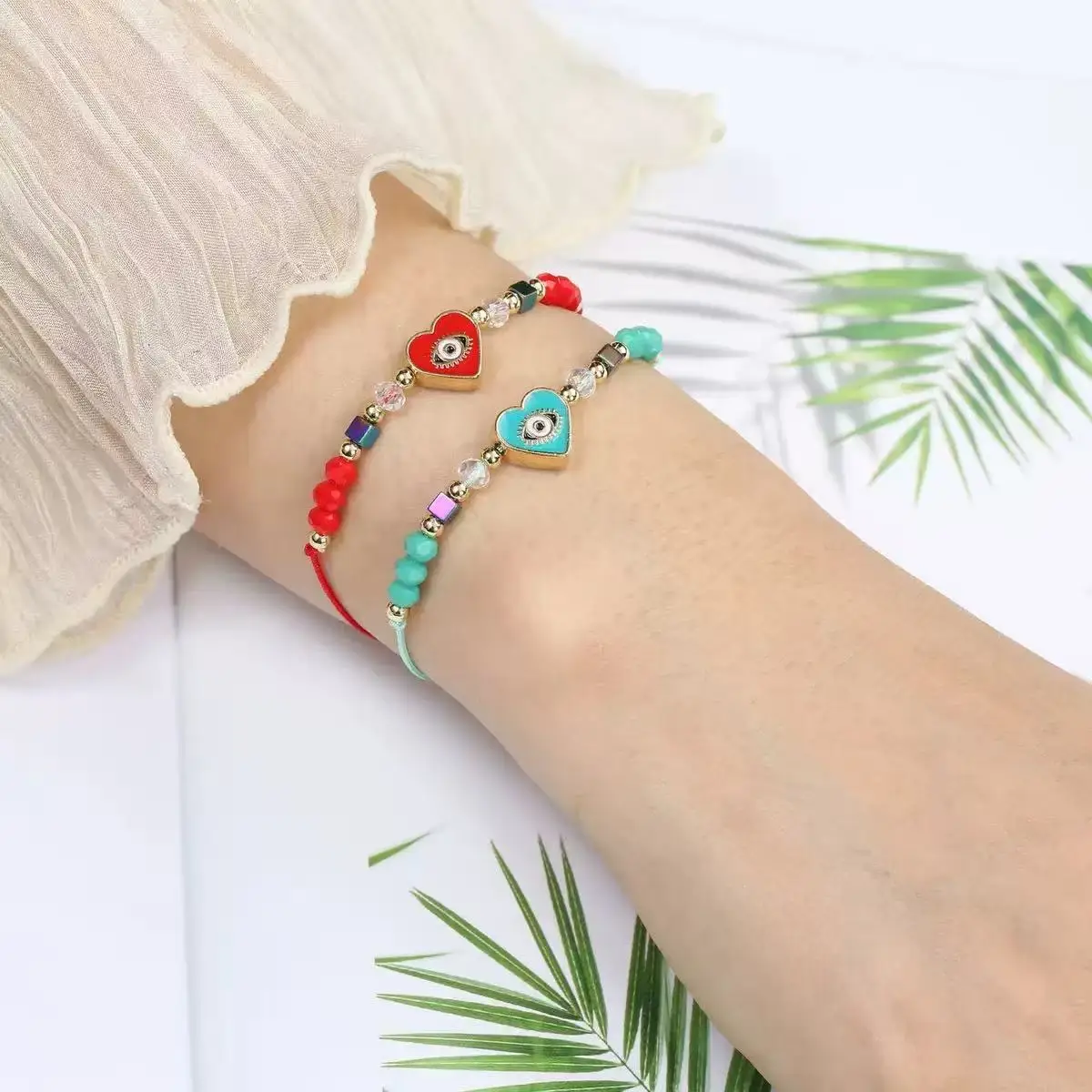 Un juego de 12 piezas de pulsera ajustable de moda europea y americana tejida con cristales de mal de ojo y corazón que gotea aceite