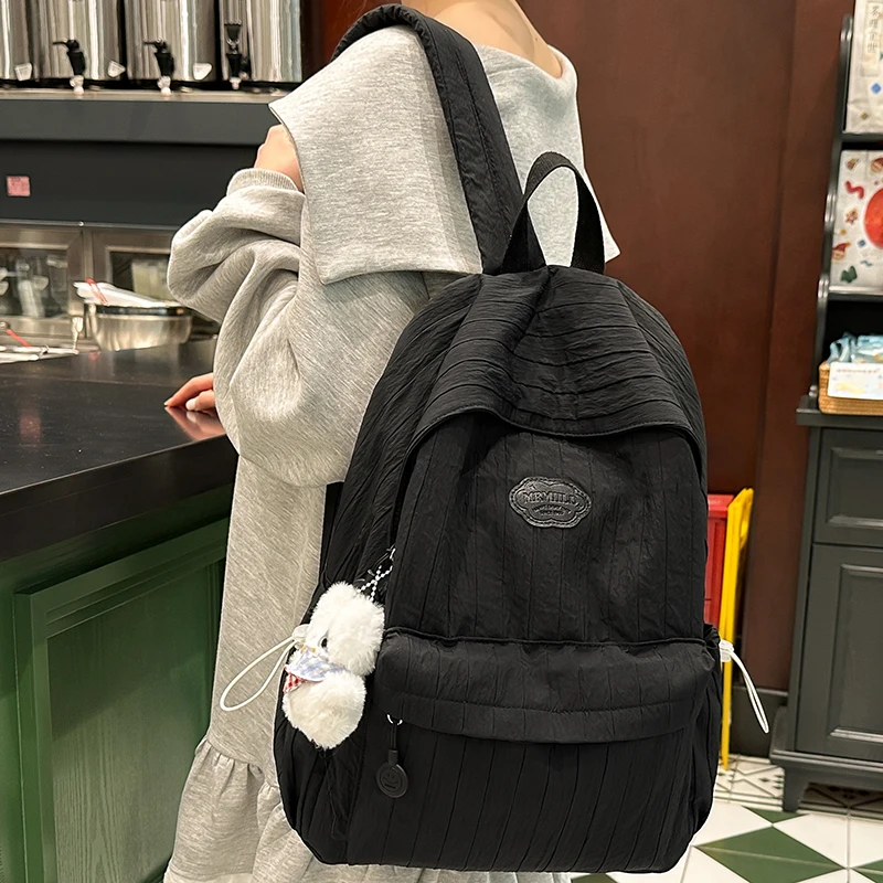 Coreano náilon mochila feminina casual cor sólida pequena mochila de viagem para adolescente mochila escolar com decoração boneca