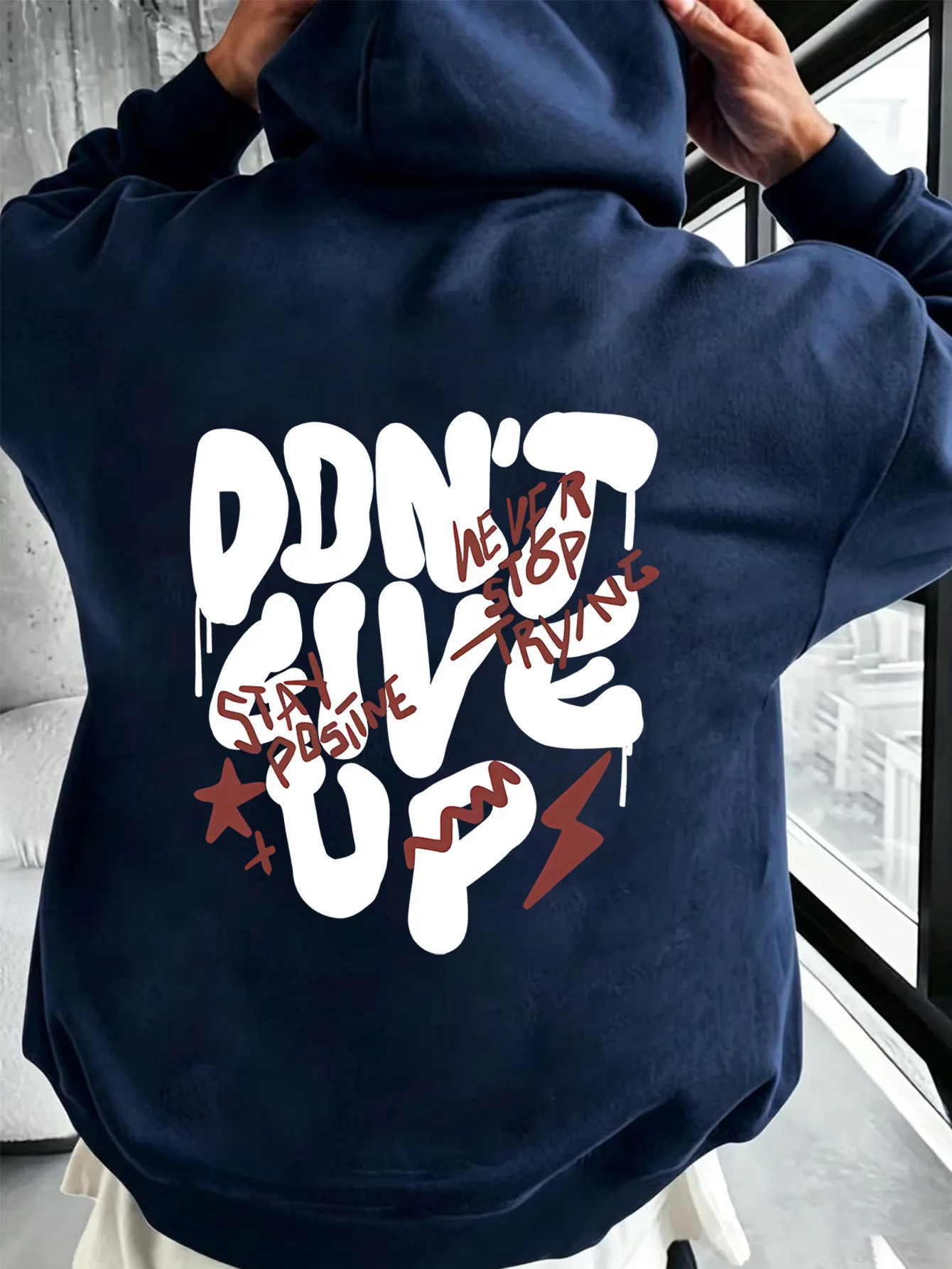 Sweat-shirt à capuche tendance pour homme avec des imprimés graphiques audacieux et un design positif - un hoodie décontracté urbain et optimiste.