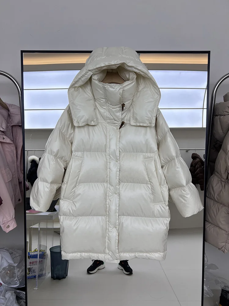 سترة نسائية طويلة بغطاء للرأس فضفاضة بيضاء مبطنة للأسفل سترة عصرية لشتاء 2025 معطف جديد بزرين على شكل قرن البقر بلون سادة #1