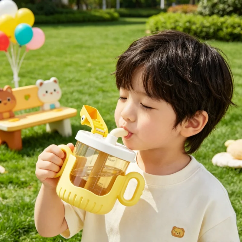 

Cartoon crocodile children's drinking cup with handle and scale. For kindergarten babies. Sippy cup for drinking milk and juice.