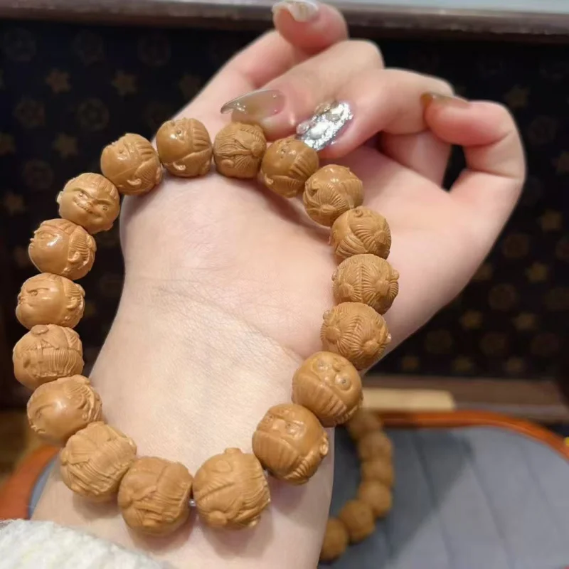 

Круглый браслет из светлых бусин с персиковым ядром и обезьяной из бисера