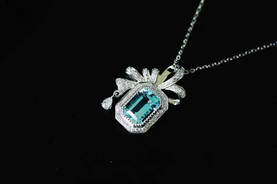 

Modern Classic 1.4ct Aquamarine Pendant, Flawless Emerald Cut, Crafted in 18K Gold with a Diamond Border.