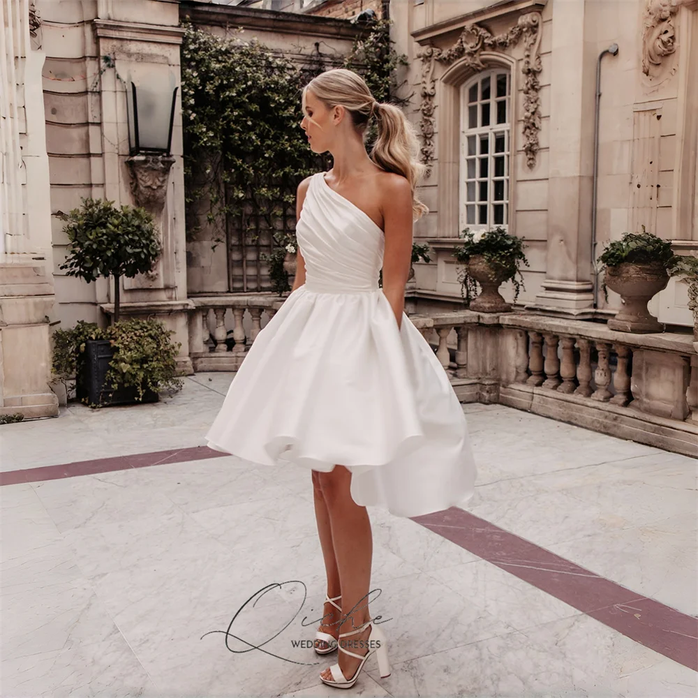 ชุดแต่งงานทรงเอไลน์สั้นแบบไฮโลว์ ผ้าซาตินทันสมัย แบรนด์ QICHE แบบไหล่เดียว จับจีบ แขนกุด เปิดหลัง  สามารถสั่งตัดได้