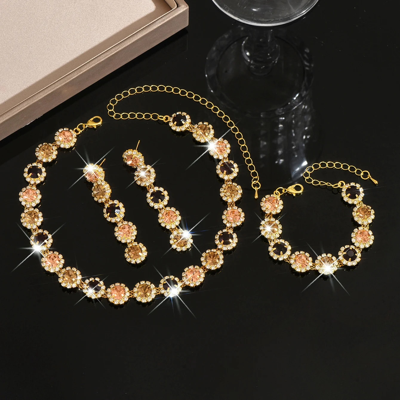 

Набор из четырех предметов: украшения с круглыми камнями в виде цветов и бриллиантами, полный комплект: цепочка на ключицу, серьги и браслеты.