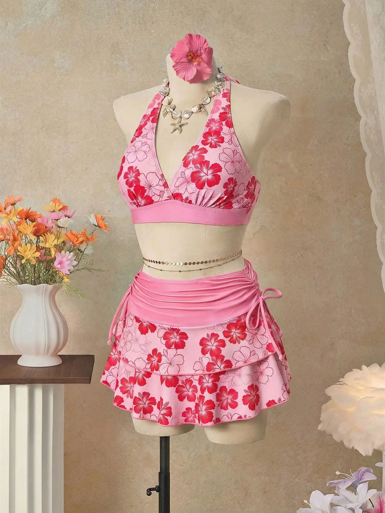 

Розовый комплект из трех предметов: бикини с цветочным принтом, топ-халтер и юбка для пляжа и курорта