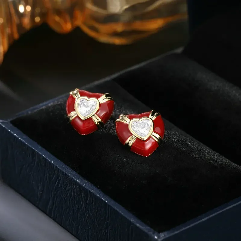 Il nuovo design di nicchia del 2025 di orecchini a forma di cuore presenta uno stile semplice e può tirare orecchini a bottone rossi a forma di cuore