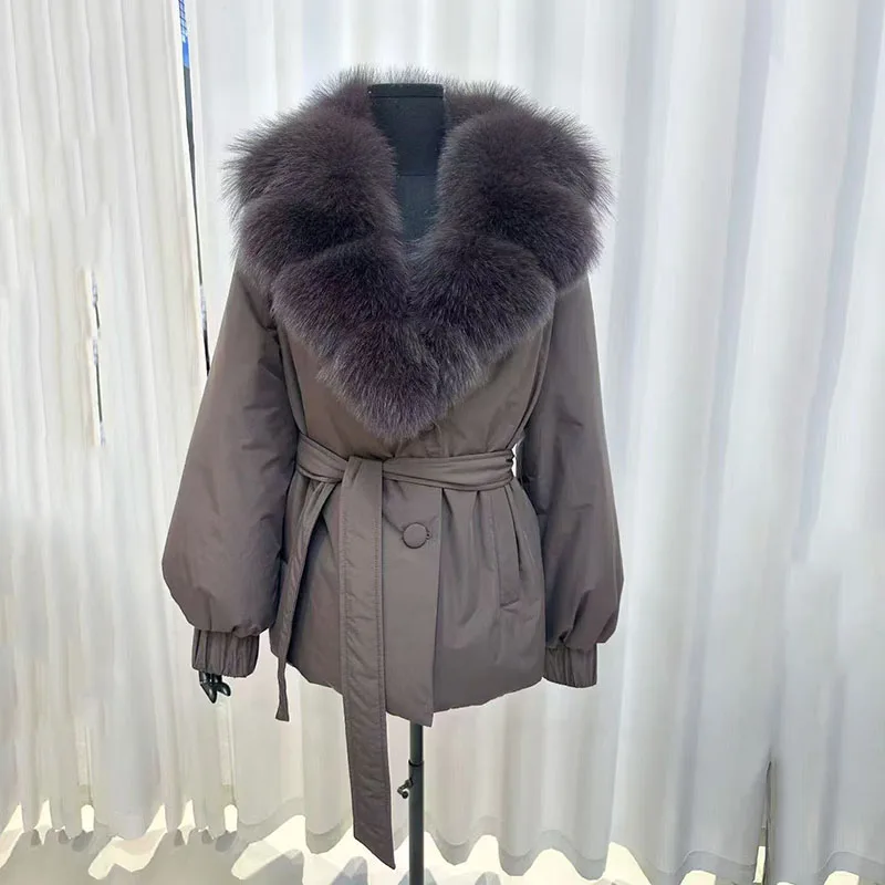 سترة شتوية جديدة لعام 2025 بياقة كبيرة من فرو الثعلب للنساء، معطف سميك عصري قصير برباط على الخصر