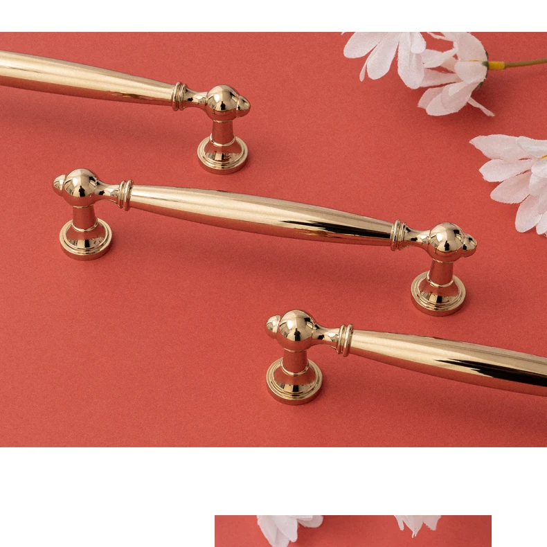 Two gold handles with shaped ends in close view