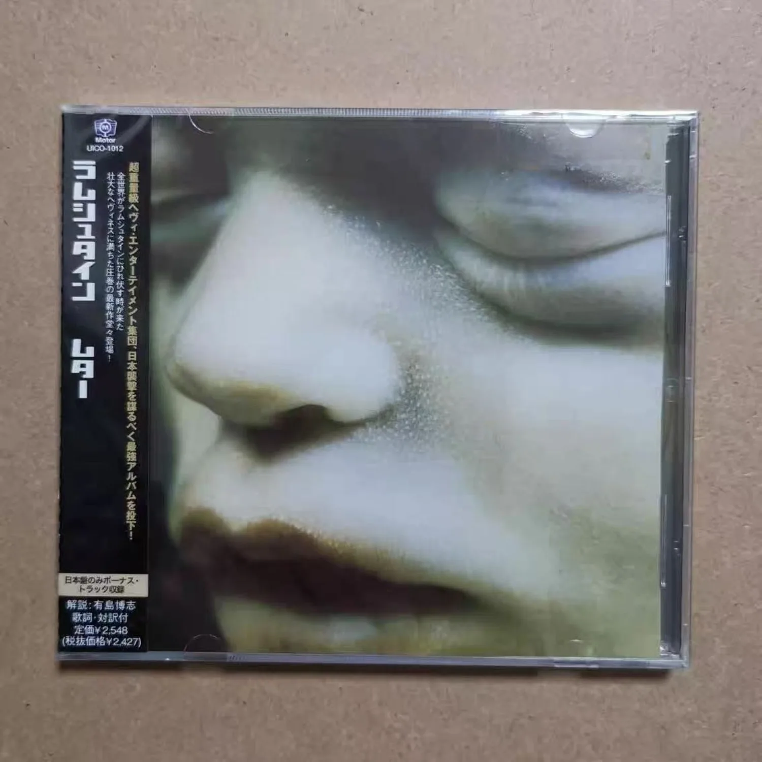 Caja de CD de audio industrial alemana de la marca japonesa Press, con portada de retrato de primer plano de ojos cerrados en tonos fríos, para colección de heavy rock.