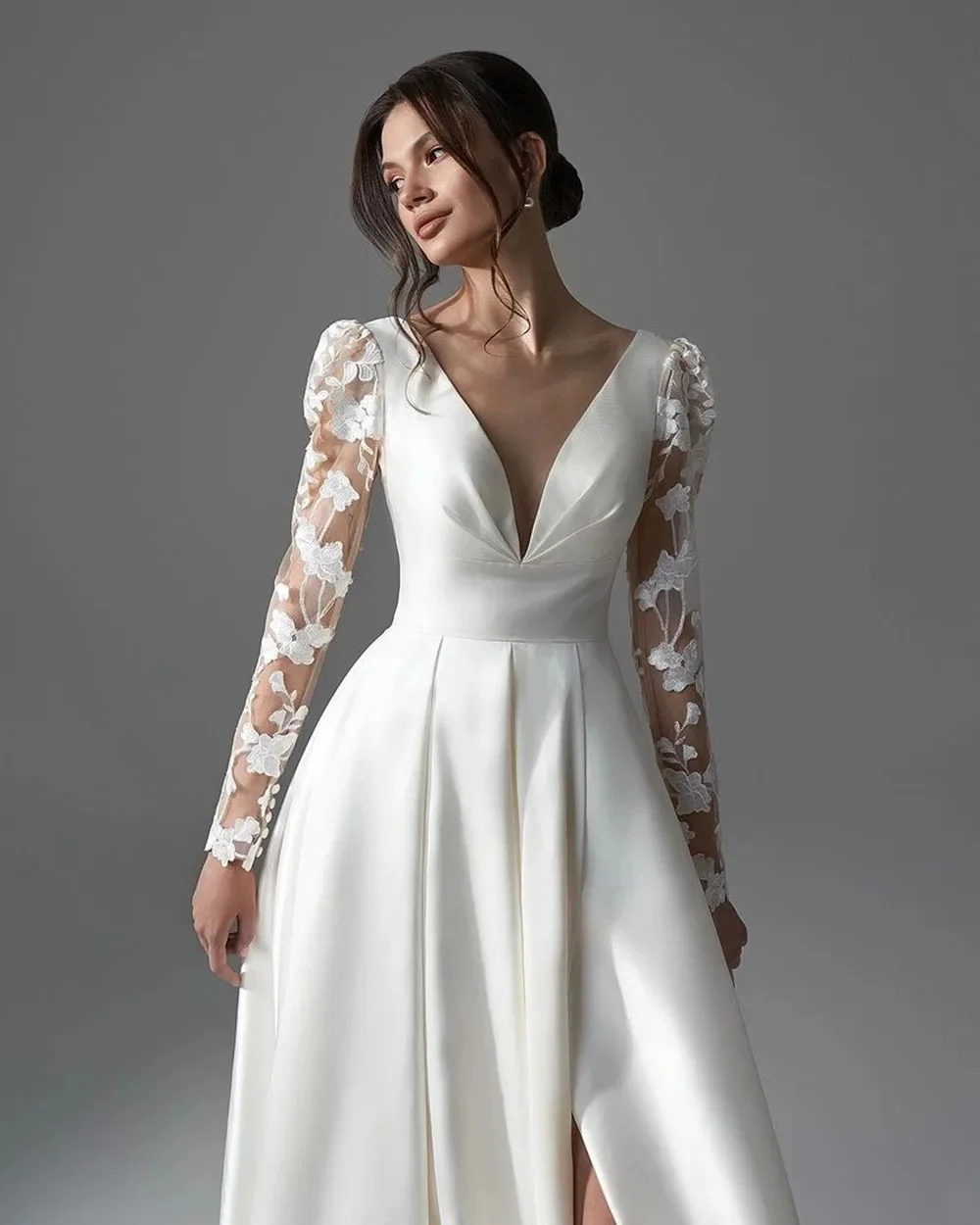 

Exclusive custom white formal dress with V-neck lace and long sleeves. Waist design flatters figure. Lovely small train creates