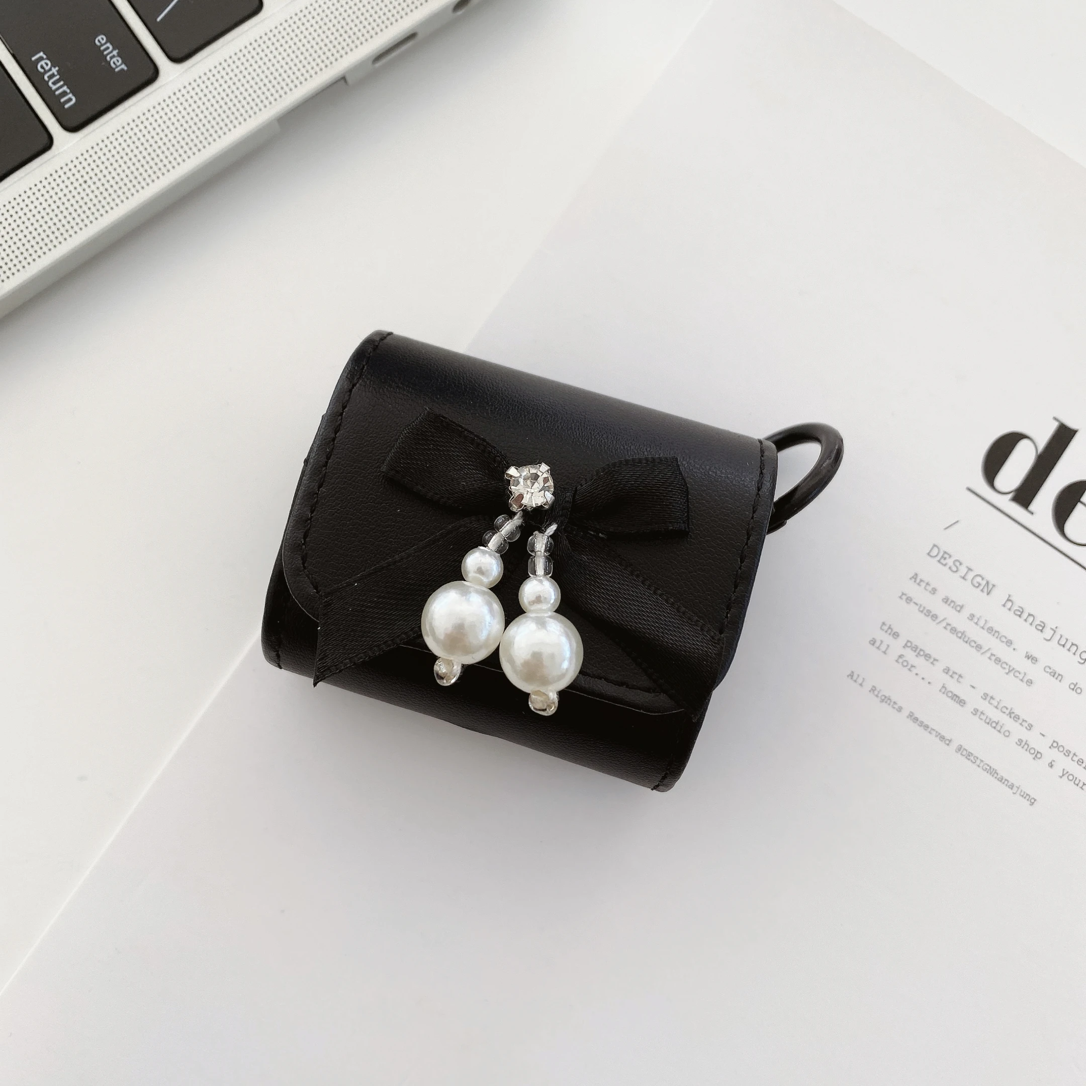 حافظة سماعات عصرية فاخرة من جلد البولي يوريثان مع عقدة على شكل فيونكة لؤلؤية كريستالية باللون الأسود والأحمر مع خطاف لأجهزة AirPods 1 2 3 4 Pro2 Pro 3