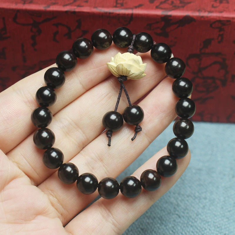

Ebony 8mm bracelet with boxwood lotus design, unisex cultural accessory prayer beads