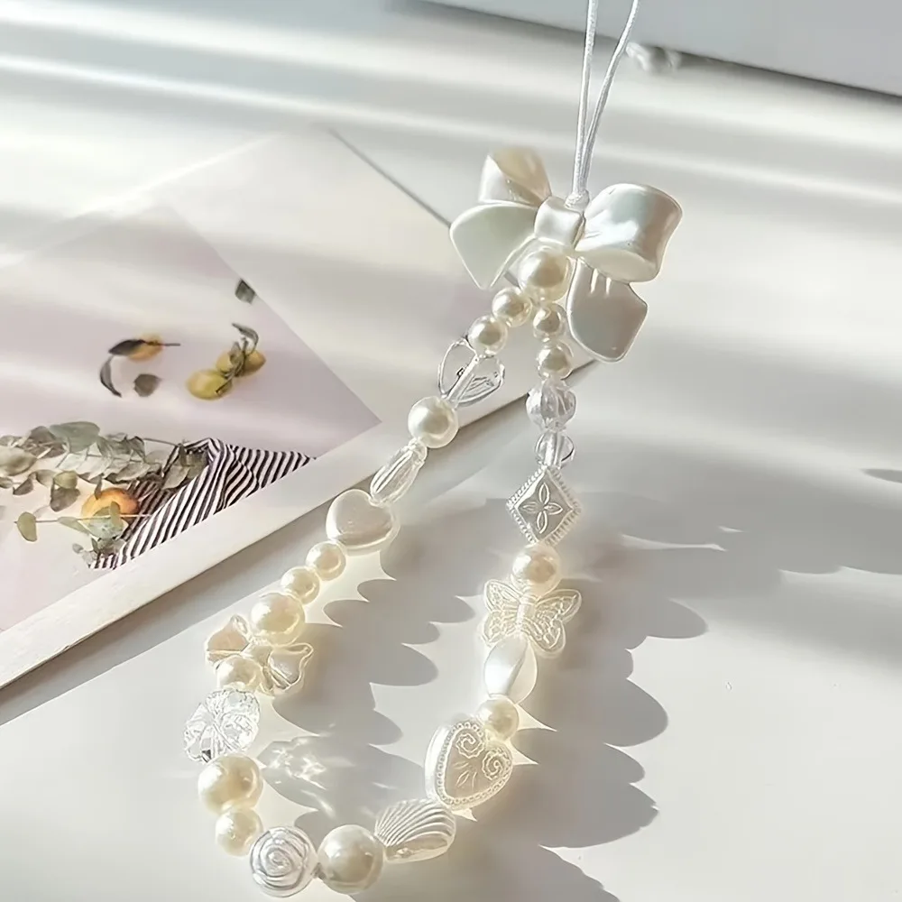Elegancka smycz z białej perły z zawieszkami w kształcie motyla i serca, plastikowy pasek na nadgarstek z kokardką do identyfikatora i kluczy — zdjęcie 4
