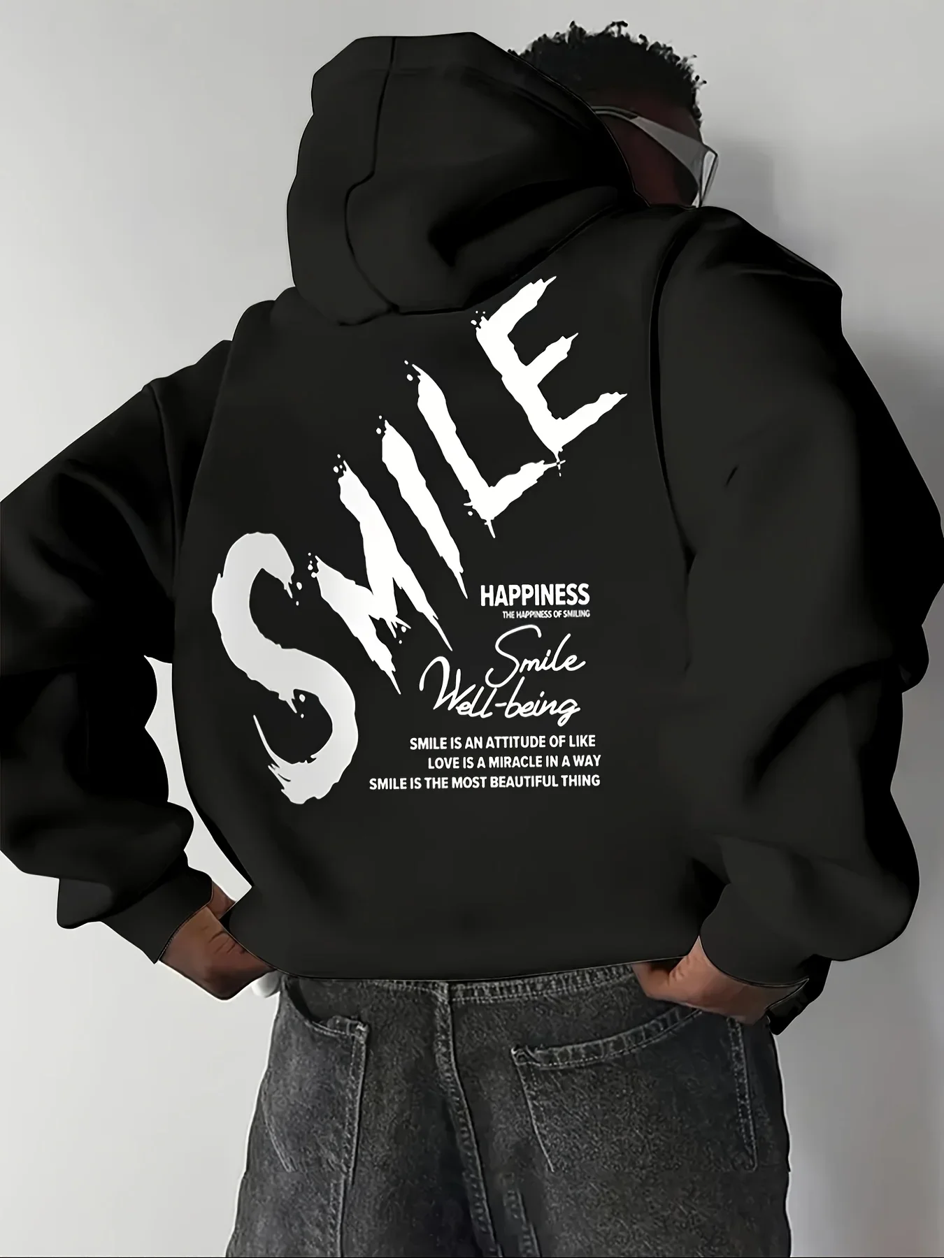 Sudadera con capucha negra holgada unisex con estampado trasero de letras SMILE estilo grafiti y tipografía moderna para hombre, estilo hip-hop streetwear.
