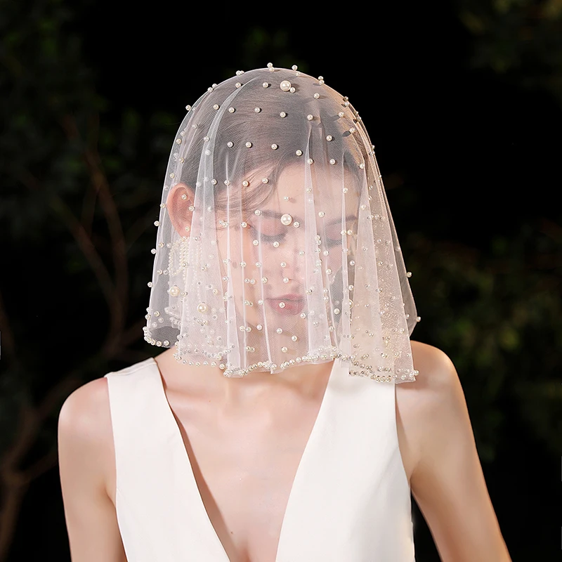 A white elegant bridal veil adorned with simulated pearls suitable for women's weddings (excluding earrings)