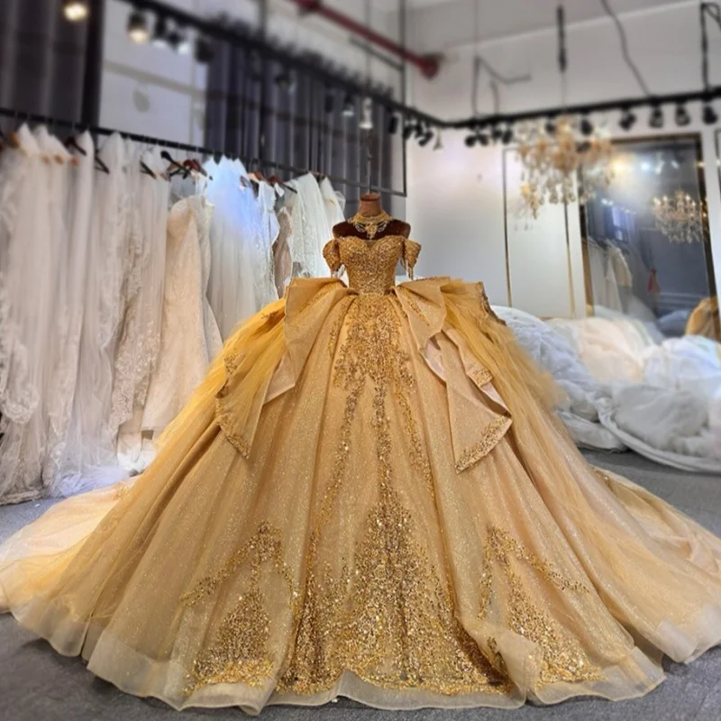 

Платья для квинсеаньеры цвета шампанского золота с блестящими кристаллами, открытыми плечами, многослойной отделкой, длинным шлейфом и бантом, на заказ.