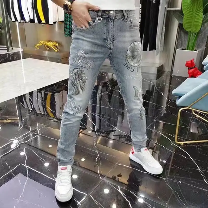 Celana jins Denim ramping pria, pakaian mewah Korea, celana jins kurus abu-abu musim semi musim gugur kasual berlian imitasi cetak timbul untuk pria