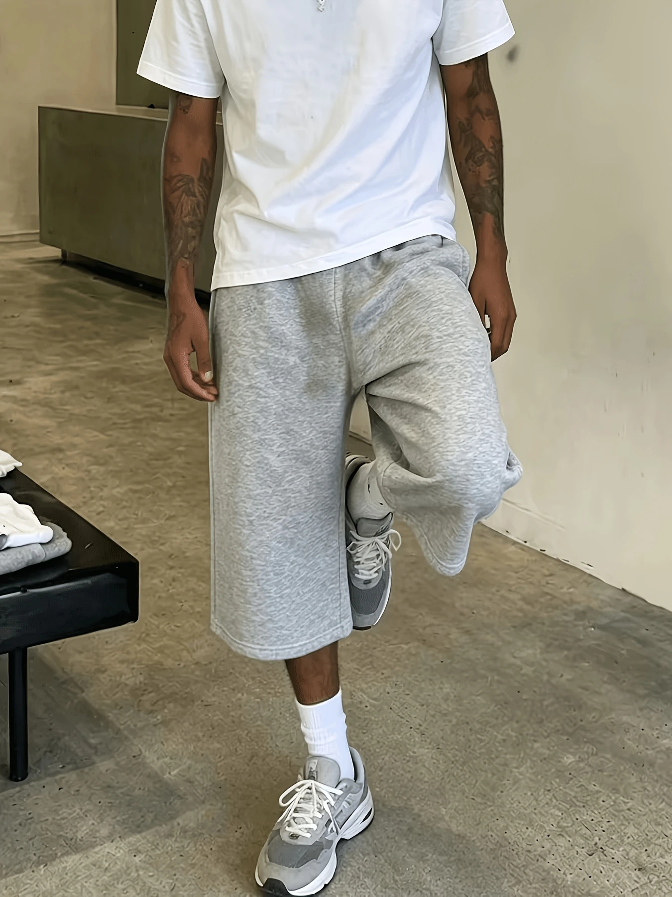 Calções casuais cinzentos para homem, de corte folgado e pernas largas, estilo streetwear/hip-hop. Calções desportivos e modernos para atividades físi