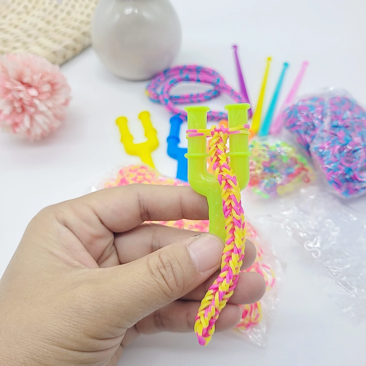 

Набор для изготовления браслетов дружбы, включает 2 большие пластиковые рогатки, 2 пластиковых крючка для вязания, 100 прозрачных S-образных зажимов, 100 цветных S-образных зажимов, 450 розовых и синих резинок, 450 розовых и желтых резинок, набор для само