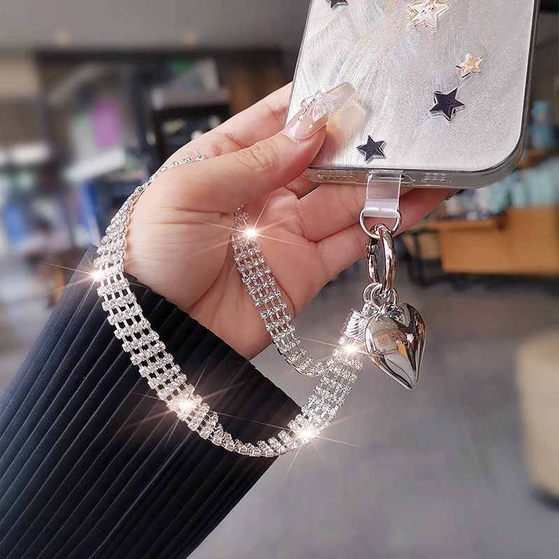 

Роскошный блестящий ремешок для телефона с серебряным кулоном в форме сердца из стразов, изысканный и элегантный аксессуар для телефона, ремешок на запястье.