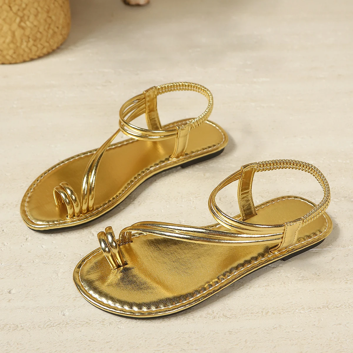 Neu eingetroffene Damen-Sandalen mit metallisch-goldener Zehenklemme, flachem Absatz, elastischem Knöchelriemen, im Bohemian-Stil für Strand, Urlaub und Freizeit. – Detail 5