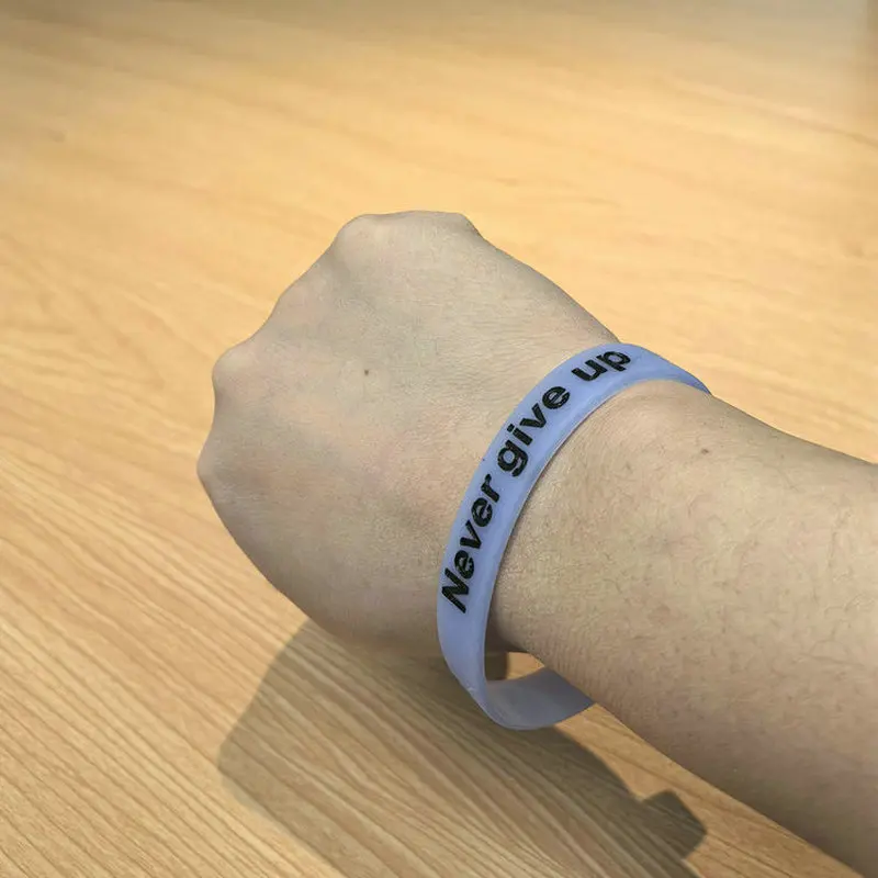 سوار معصم من السيليكون المتوهج في الظلام مع طباعة "لا تتخلى أبدًا" - سوار رياضي تحفيزي، مريح ومتين، متعدد C