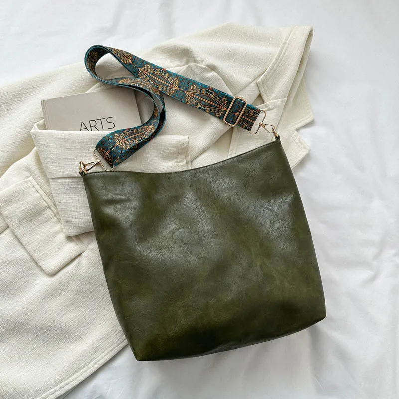 Sac tendance 2025 A/W avec une large sangle. Cuir souple, spacieux et rétro-chique pour un transport élégant et confortable.