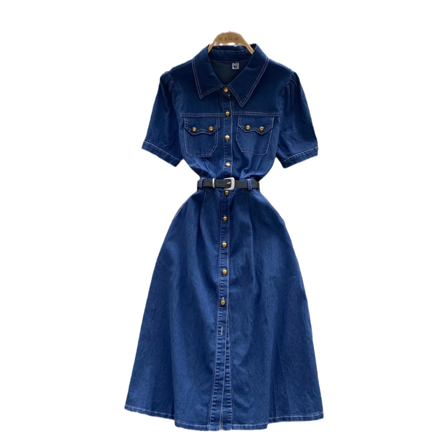Un nuovo abito in denim alla moda estiva. Abito in denim a vita stretta con cintura monopetto in metallo a maniche corte con collo alto retrò per le donne