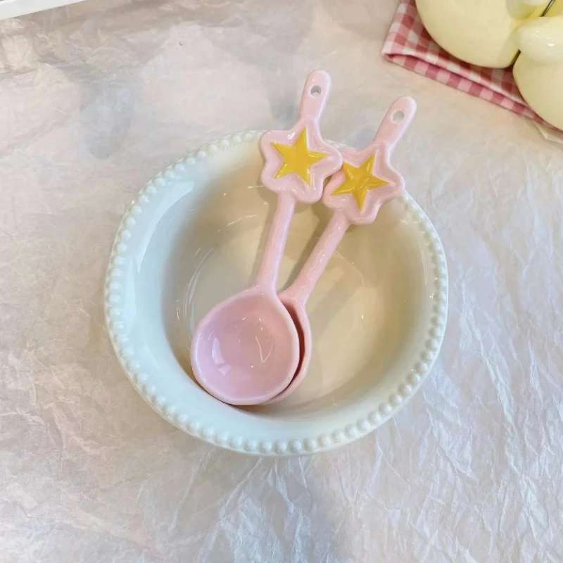 Ensaladera de postre con perlas de color amarillo leche, cuchara de estrella, vajilla de cerámica