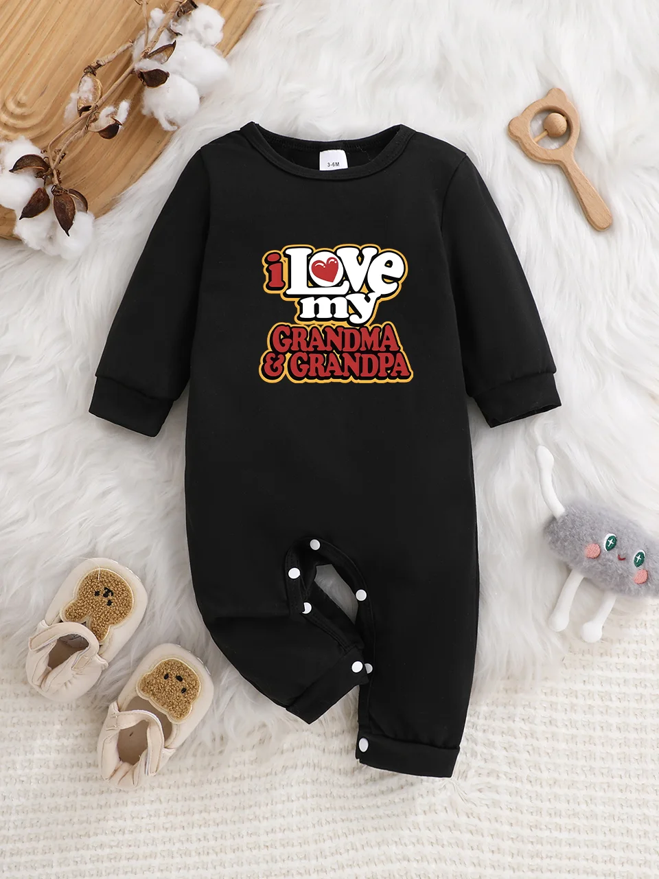 Ein langärmeliger Baby-Strampler mit interessanten Buchstaben-Prints. Es verfügt über ein Knopfverschluss-Design für einfaches An- und Ausziehen.