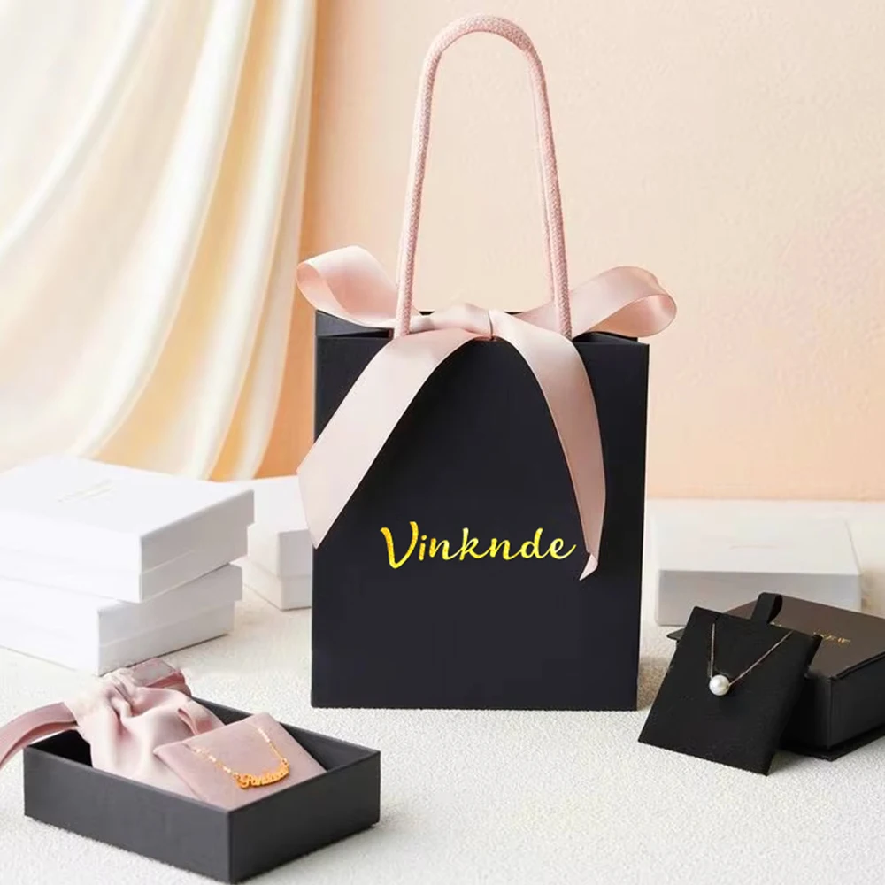 

Custom Logo Bulk Reusable White Black Kraft Paper Shopping Bags Portable Travel Wedding Gift Packaging Pouches With Bow Ribbon